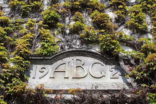 Stone engraving reading "19ABC2" covered in ivy on the exterior wall of Rufflets St Andrews.
