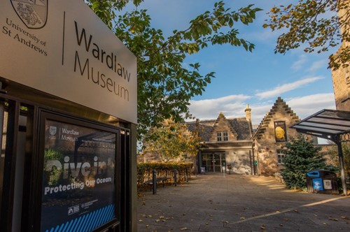 Exterior of Wardlaw Museum in St Andrews with sign promoting an ocean conservation exhibition.